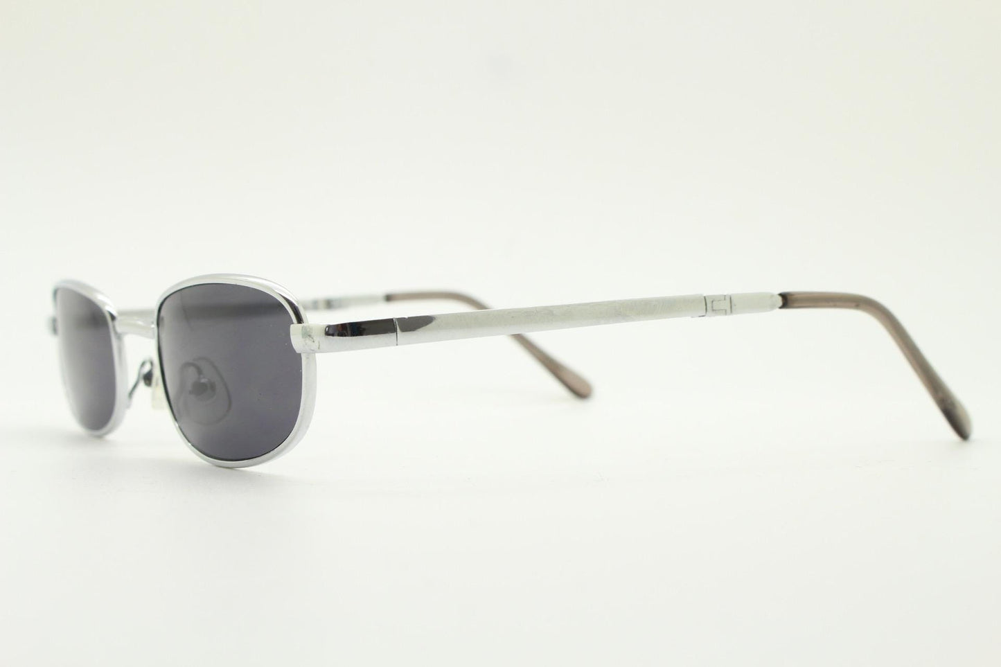 90s micro foldable rectangular sunglasses. Dark grey lenses in a small chrome folding compact frame. Folder. Rave 2000s. Y2K NOS