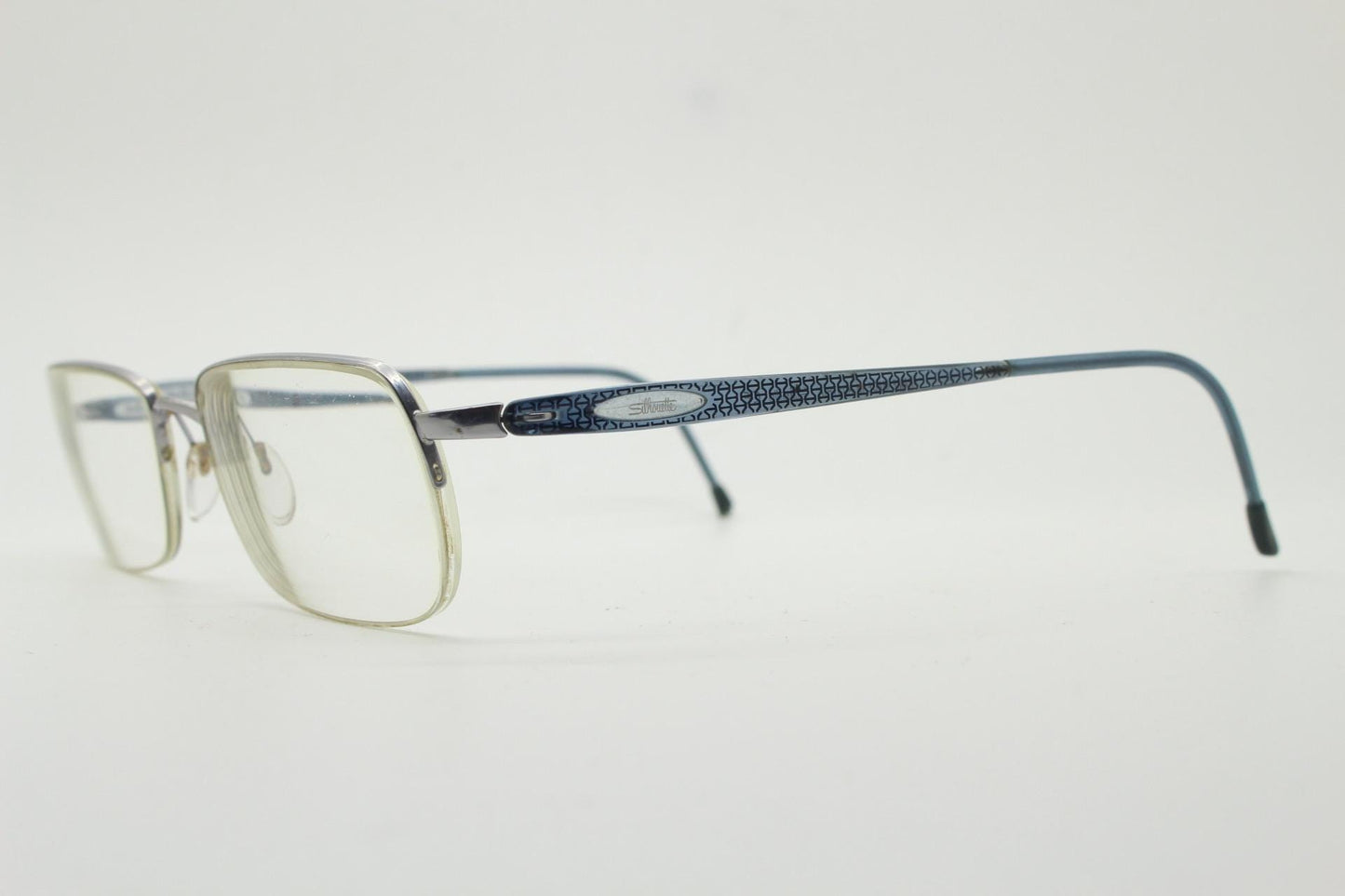 Silhouette rectangular half frame eye glasses made in Austria. Minimal brow line optical frame with patterned transparent arms. Prescription