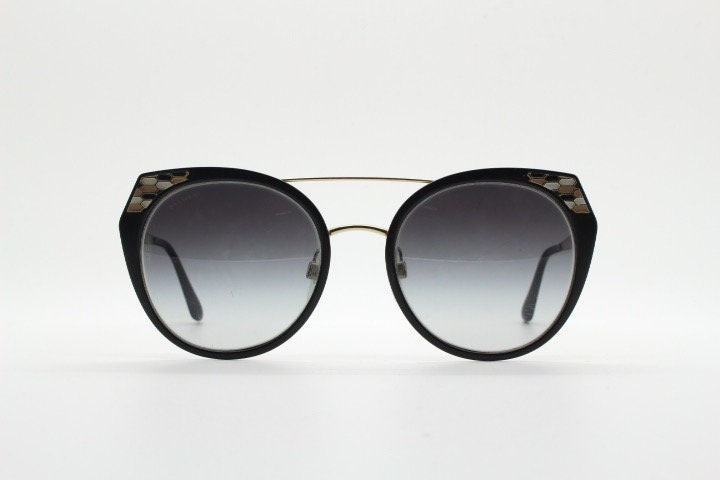 Bulgari round cropped cat eye sunglasses made in Italy. Womens black and gold frame with honeycomb patterns and smoky graduating lenses