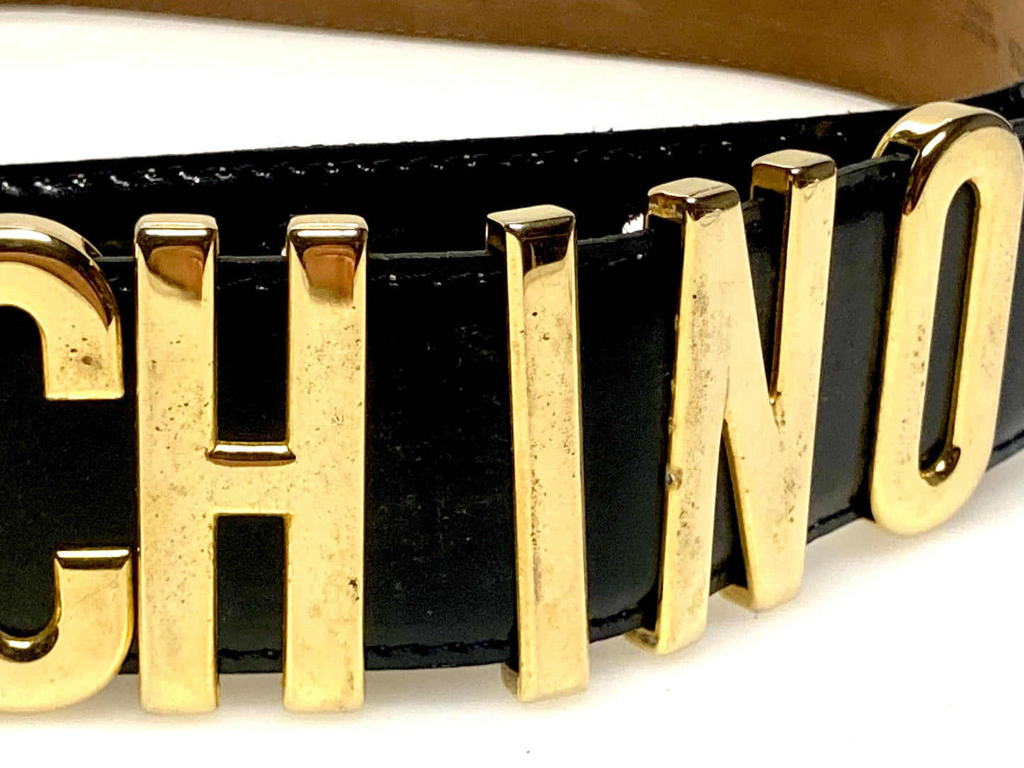 Moschino 90s vintage womens dress belt in black genuine leather. Iconic individual golden moving letters logo. Made in Italy. 80s. NOS