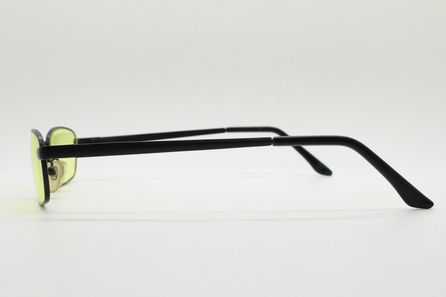 90s vintage small rectangular sunglasses. Minimal plain black matt metal frame with bright yellow lenses. Steampunk. Micro