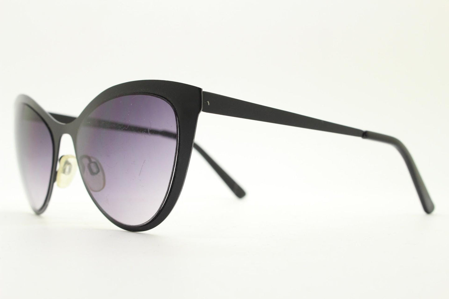 Vintage pointed cat eye sunglasses. Flat metal frame in a satin finish encasing smoky grey graduating lenses. Womens cateye