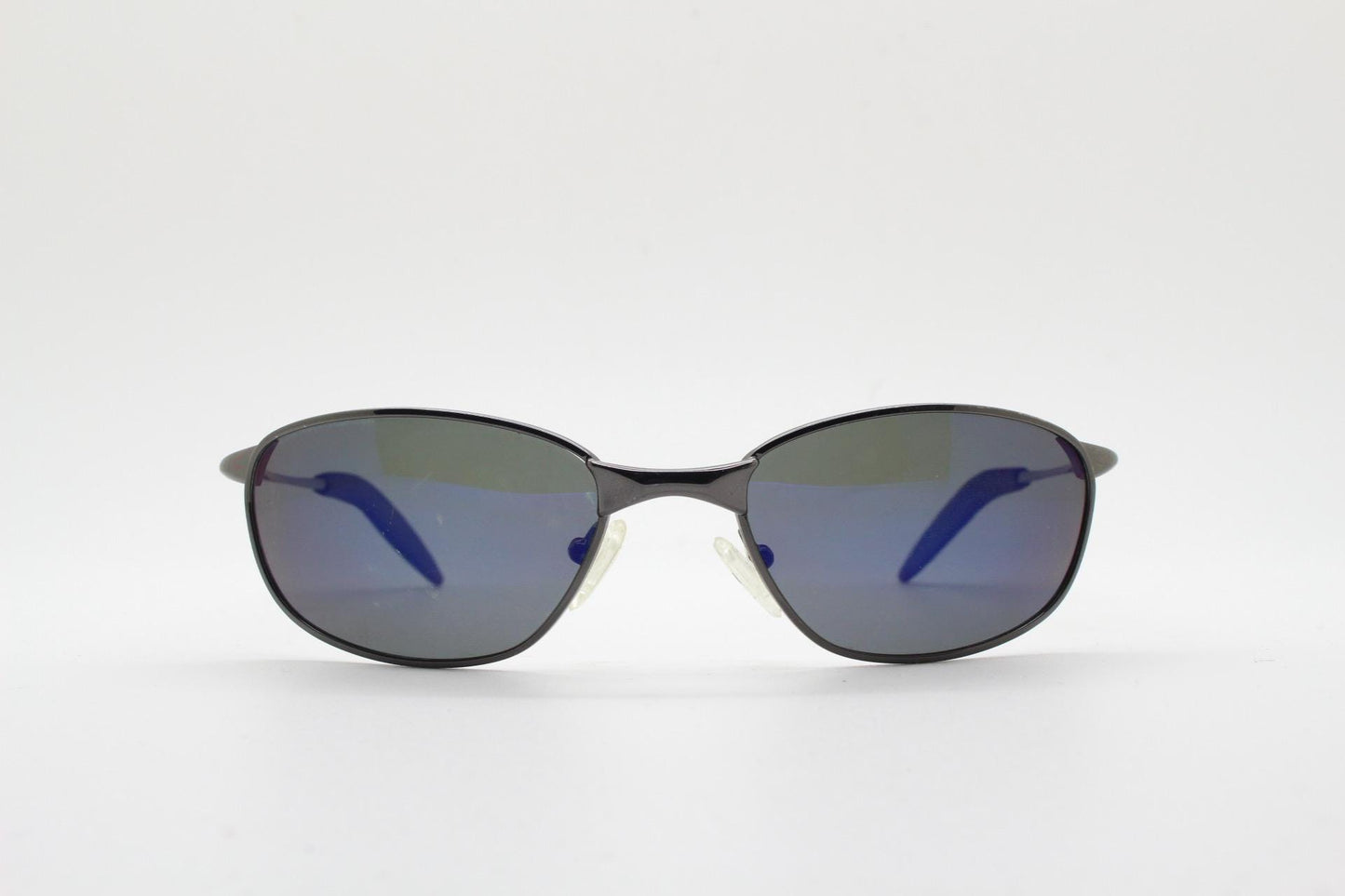 90s vintage curved oval sunglasses. Solid metal low profile frame in grey chrome with slightly mirrored dark lenses. 2000's. Y2K NOS