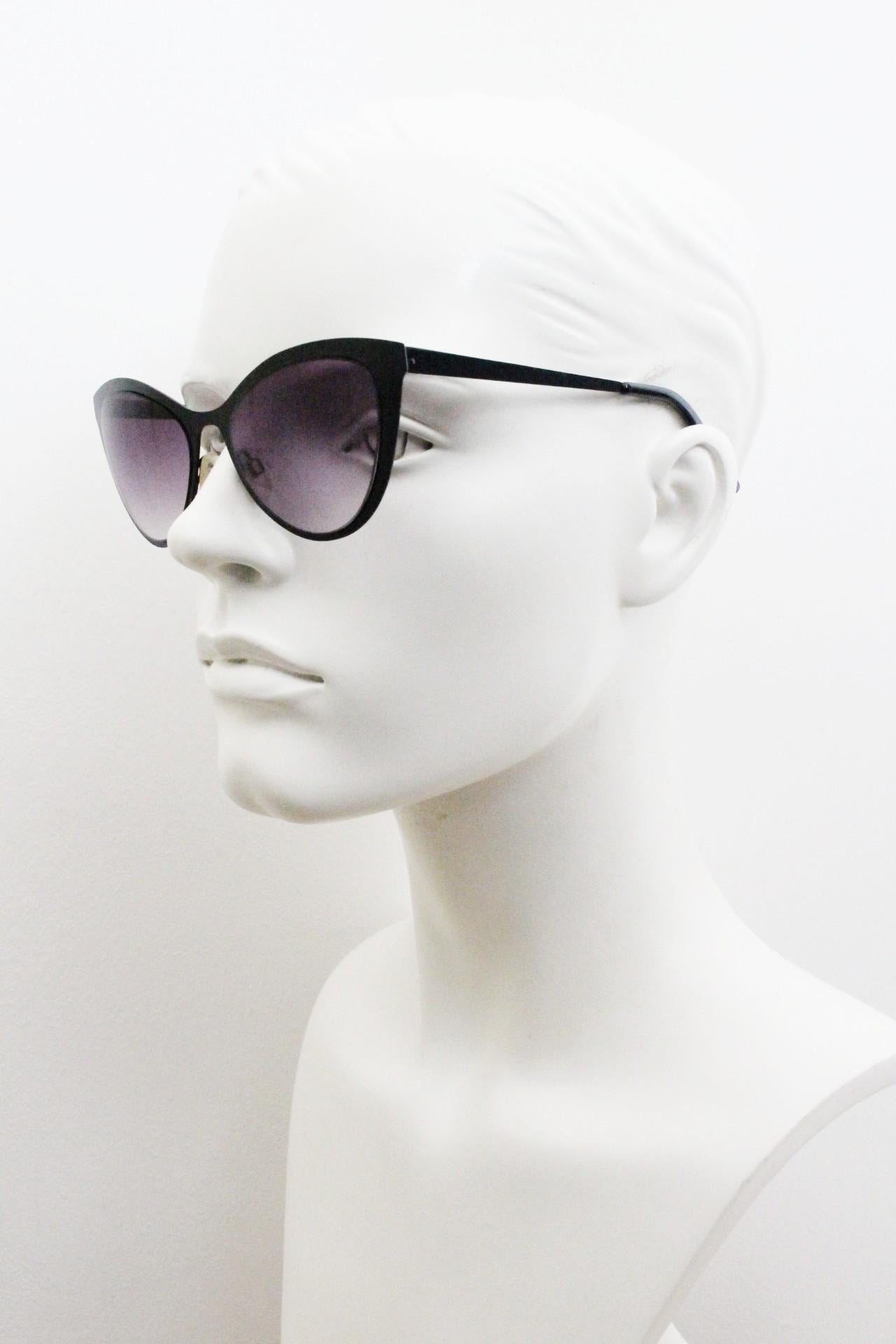 Vintage pointed cat eye sunglasses. Flat metal frame in a satin finish encasing smoky grey graduating lenses. Womens cateye