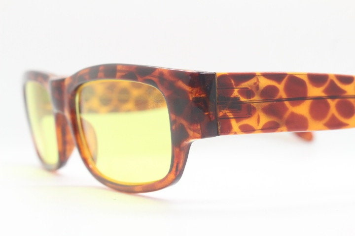 80s vintage rectangular sunglasses. Low profile 60s mod design tortoise frame with psychedelic light tone yellow lenses and fat arms. NOS