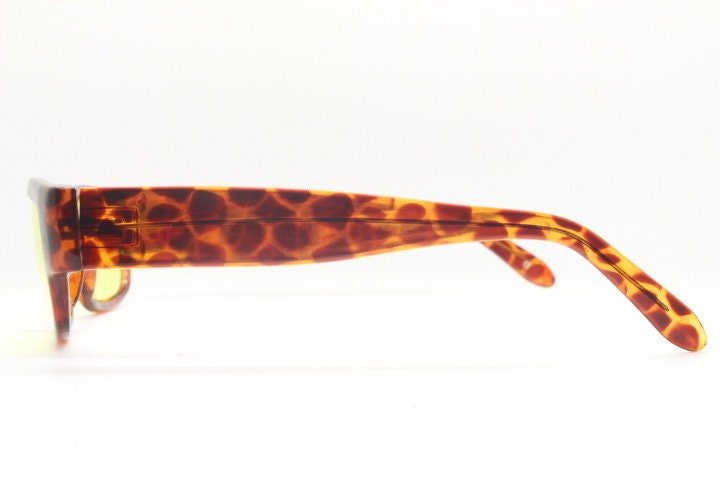 80s vintage rectangular sunglasses. Low profile 60s mod design tortoise frame with psychedelic light tone yellow lenses and fat arms. NOS