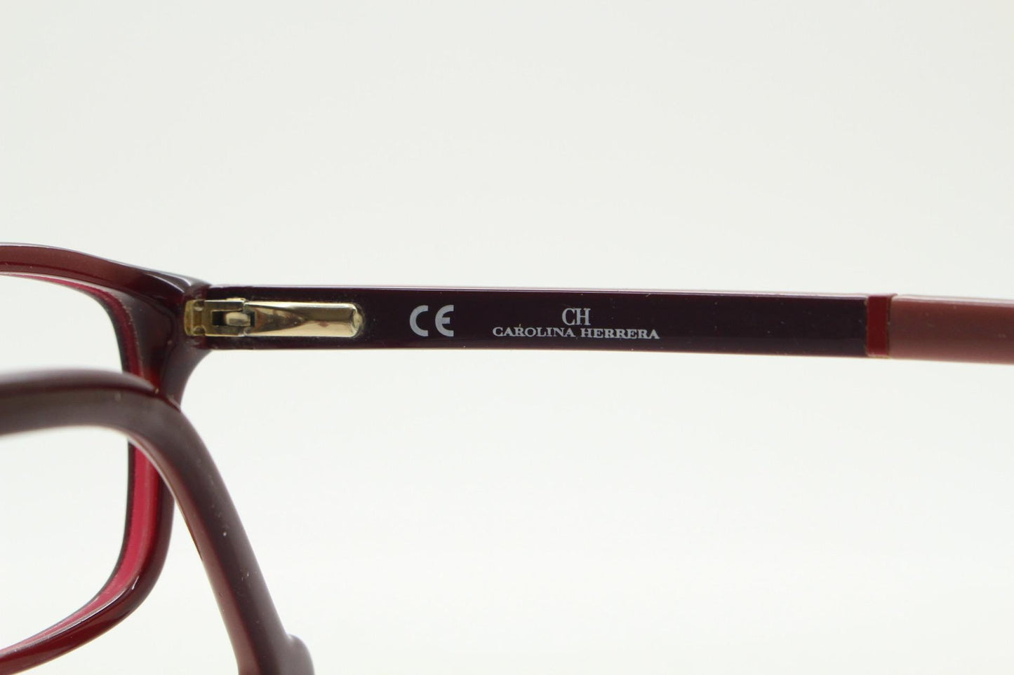 Carolina Herrera rectangular low profile eye glasses. Dark pink acetate optical frames with tasteful arm logo. Prescription RX eyeglasses