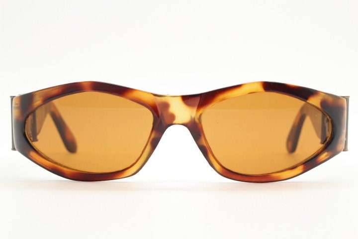 90s vintage oval sunglasses. Low profile transparent tortoise frame with massive bronze metal arm crests BNWT. Unused NOS