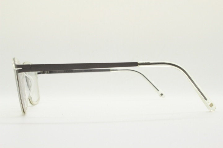 Modo rectangular eye glasses made in Japan. Matt grey titanium optical frame encasing transparent crystal acetate front. Prescription RX
