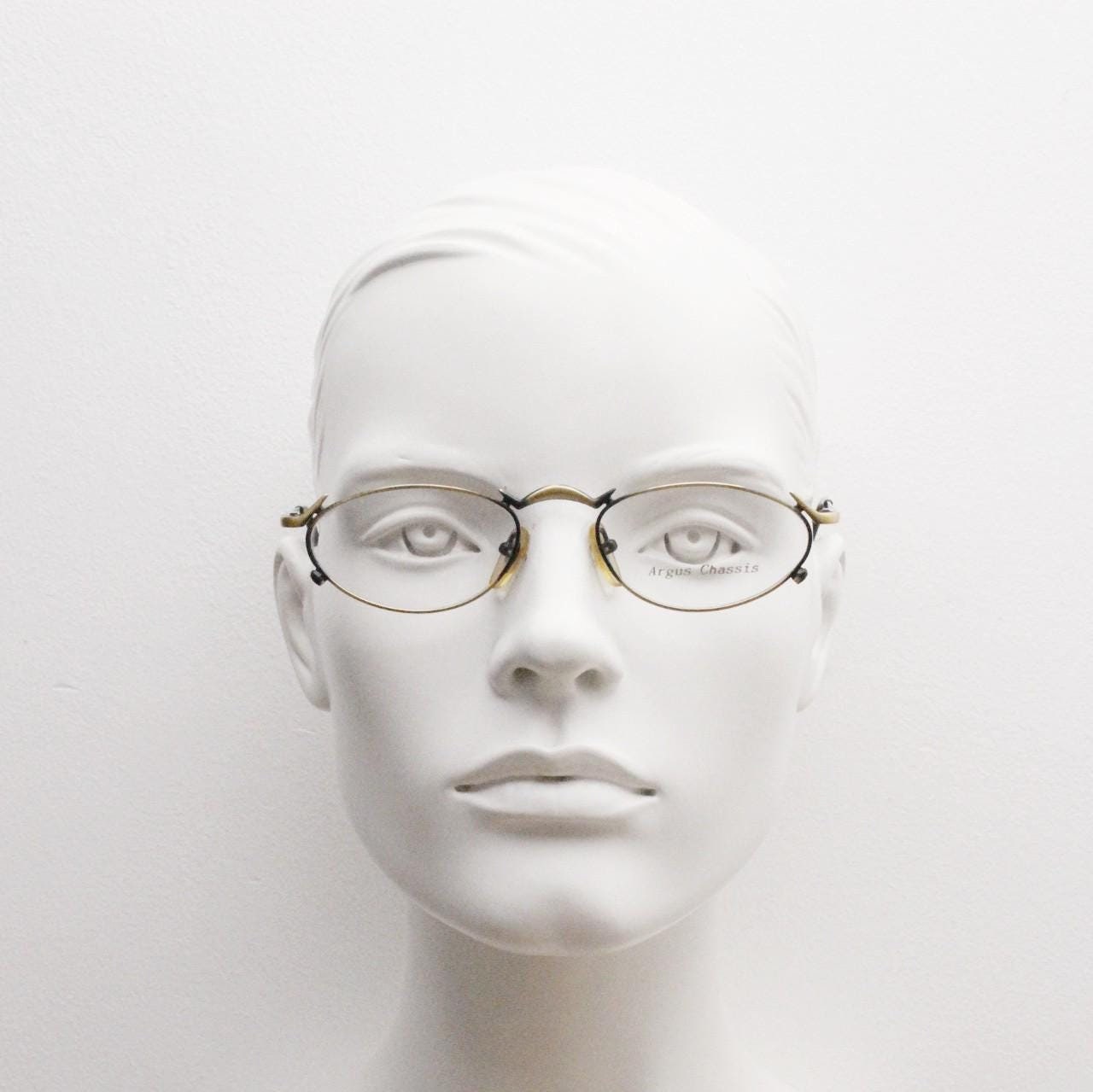 90s vintage oval eye glasses by Argus Chassis. Brushed bronze optical frames with dynamic spikes. Prescription cosplay fetish spectacles NOS