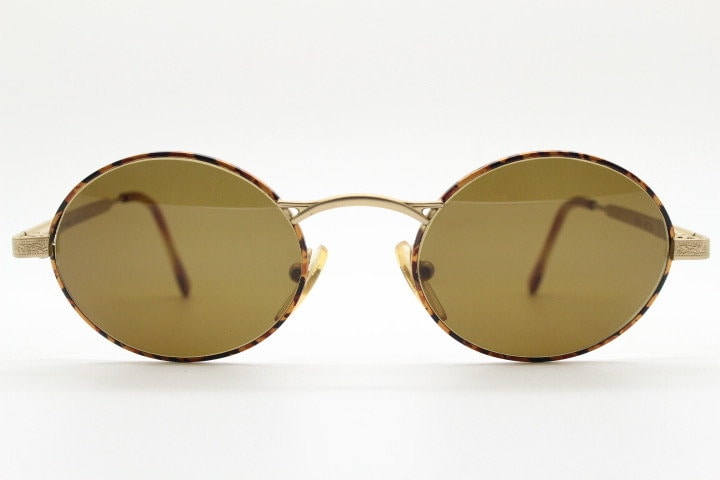 Armandos 90s vintage oval sunglasses made in Italy. Enamelled honey tortoise front with ornate tooled metal arm patterns. NOS
