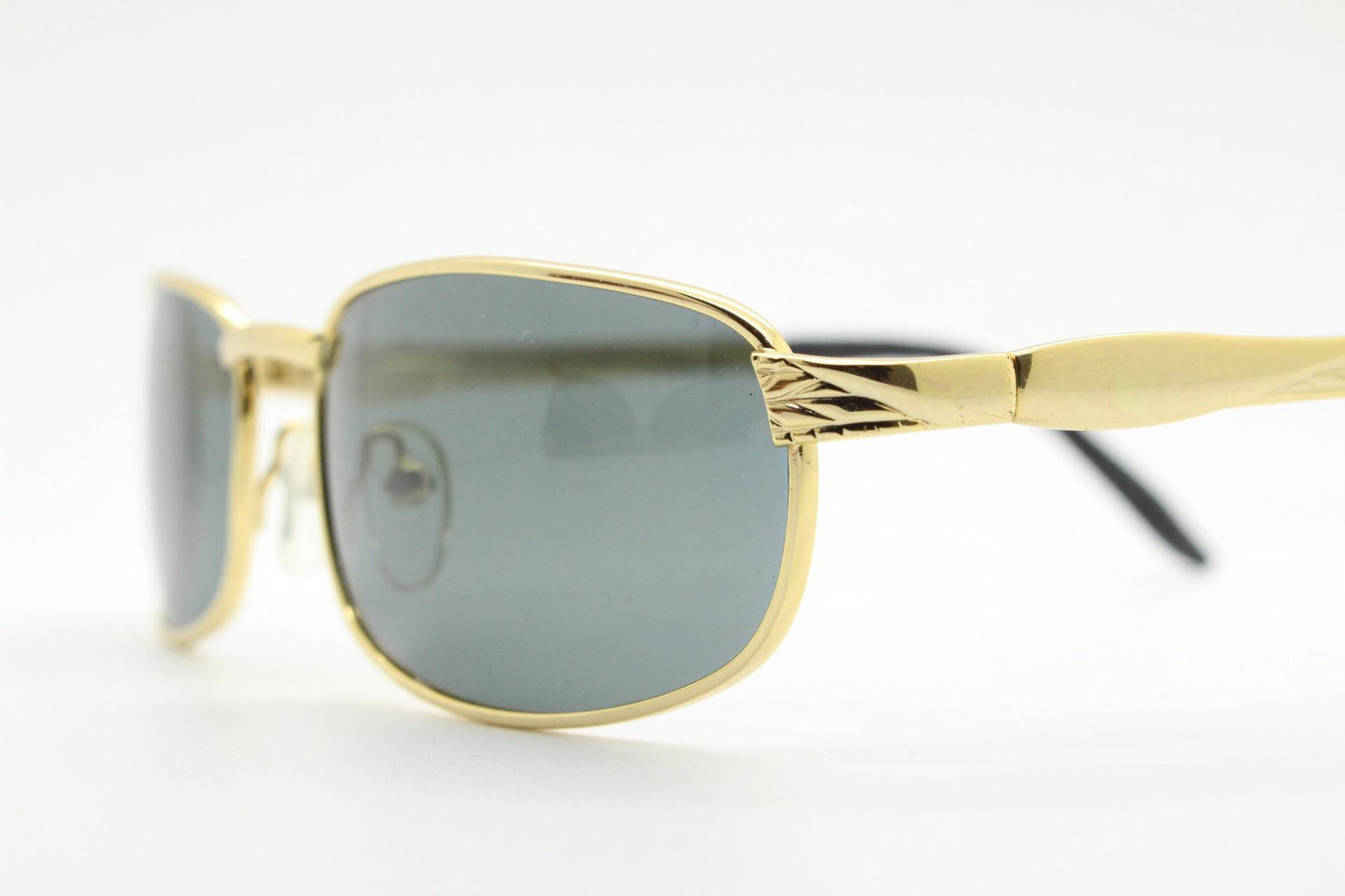 90s vintage low profile gold rectangular sunglasses. Solid metal frame in a shiny chrome finish embossed arm pattern and green lenses. NOS