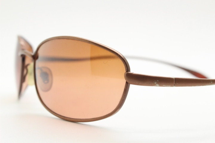 Y2K vintage oval small bug eye sunglasses. Curved copper satin finish metal frame with slender arms. Unused 2000s NOS