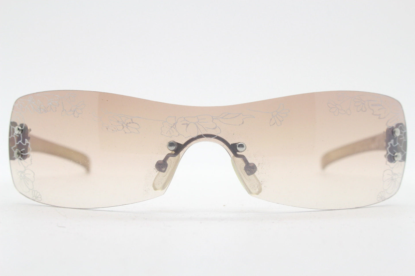 Y2K vintage visor sunglasses. Frameless 2000's wraparound mini mask shield design with light tone mono lens and flower print. 00s NOS