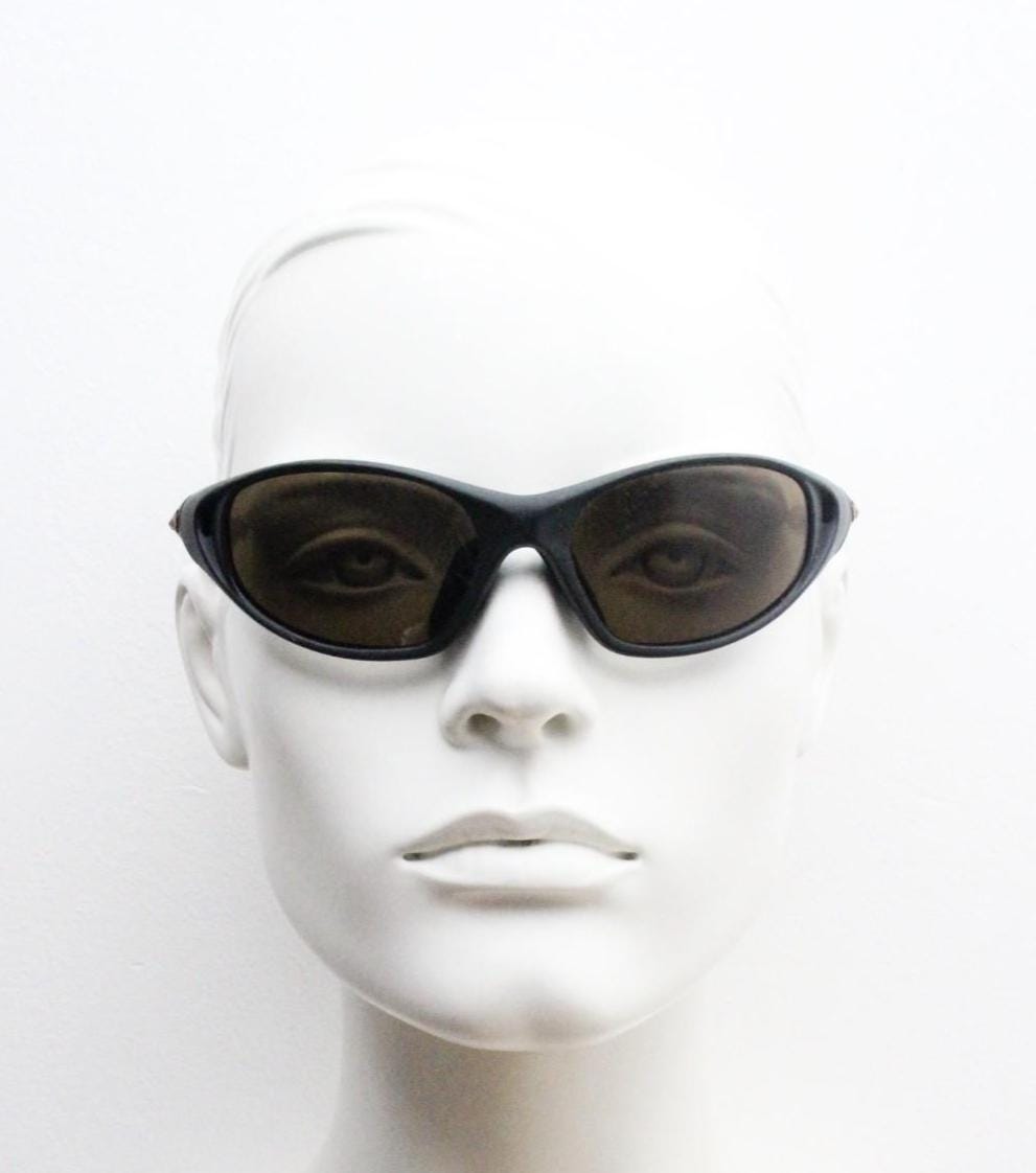 Y2K vintage sport shield aerodynamic sunglasses. All black rubber finish wraparound bug eye visor with brown lenses. 2000's. 90s