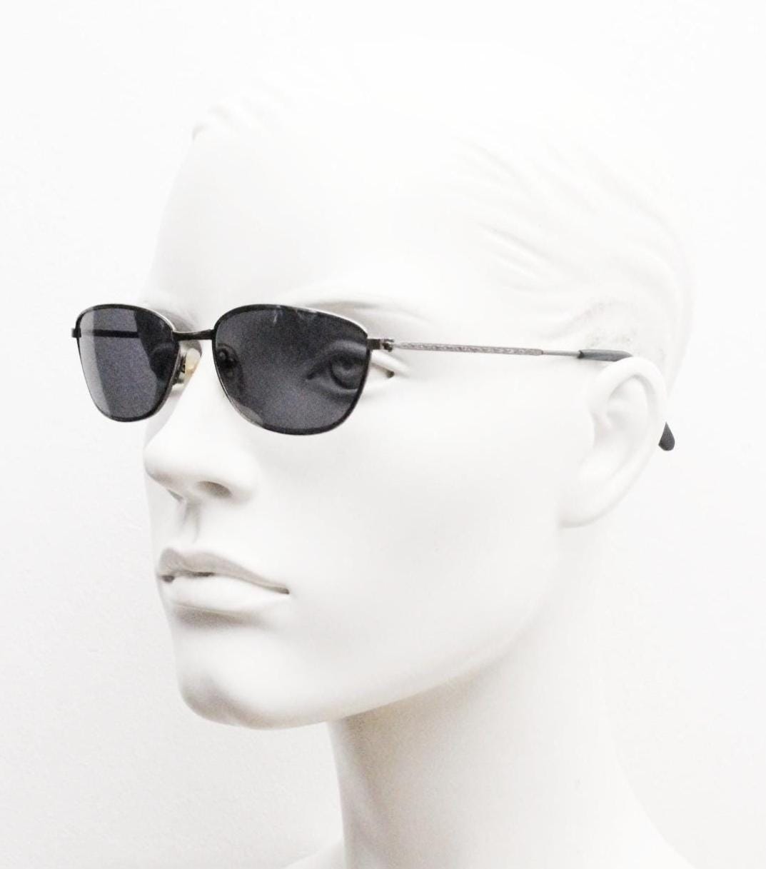 90s vintage angular pointed sunglasses. Minimal grey chrome metal frame with embossed patterned arms. Subtle cat eye. NOS