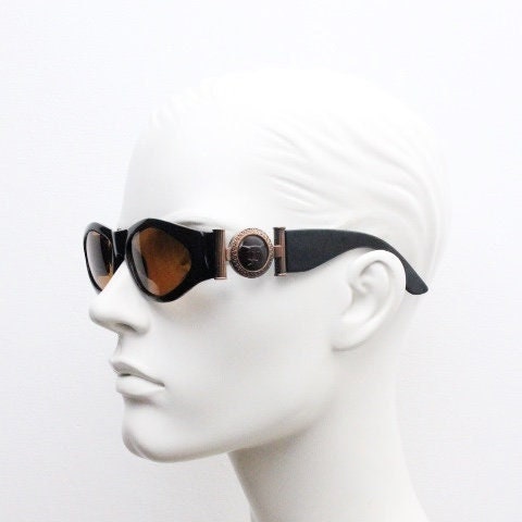 90s vintage oval sunglasses. Low profile black gloss frame with massive bronze metal arm crests and brown lenses. BNWT. Unworn NOS