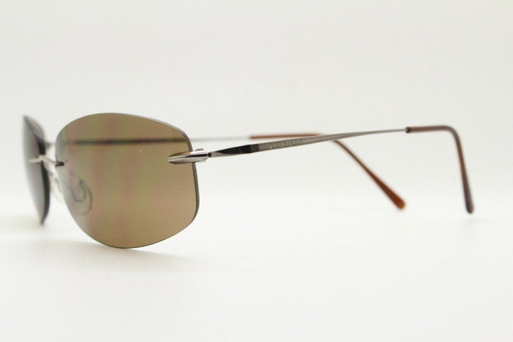 Faconnable 90s vintage sunglasses model 859 hand made in Italy. Minimal frameless design with flexible wire arms and brown chrome trim. NOS