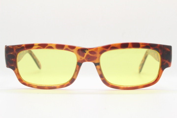 80s vintage rectangular sunglasses. Low profile 60s mod design tortoise frame with psychedelic light tone yellow lenses and fat arms. NOS