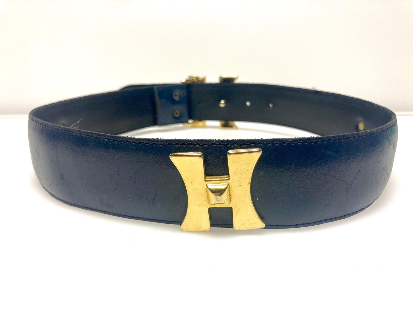 80s vintage womens dress belt in navy blue genuine leather with substantial gold chrome studded 'H' motifs. Made in France. Size S