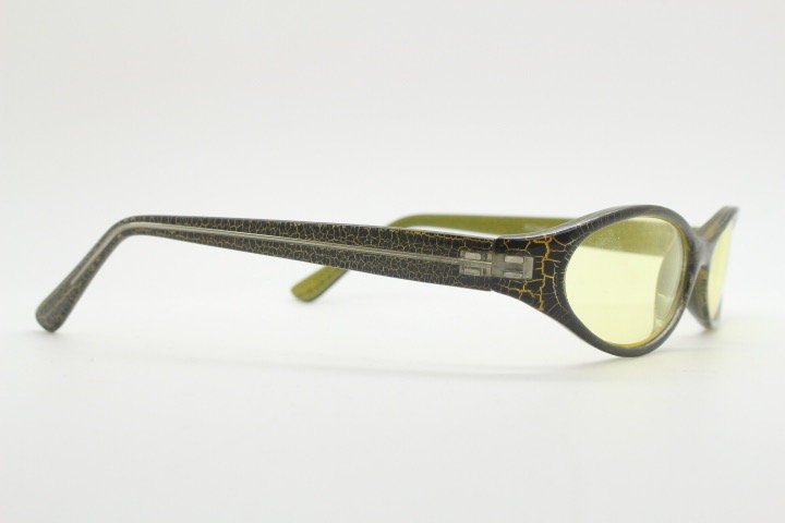 90s vintage abstract oval sunglasses. Thick curve around black frame with psychedelic yellow crackle print. Mini mask. Cosplay NOS
