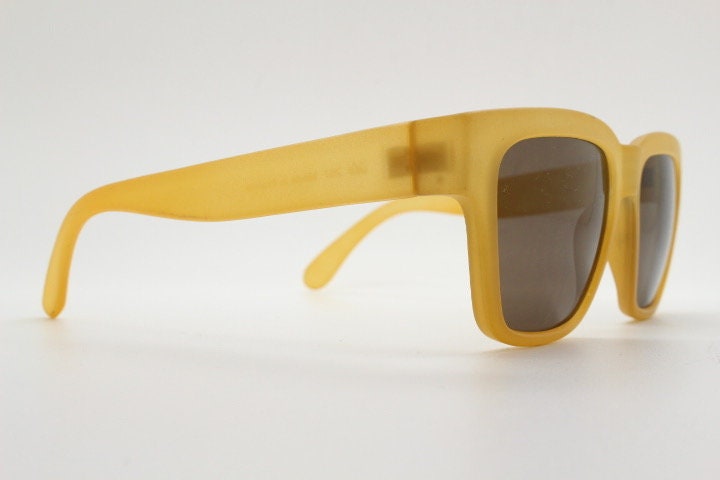 IDC lunettes modified wayfarer design sunglasses made in France. Transparent frosted yellow acetate chunky frame with contrasting lenses