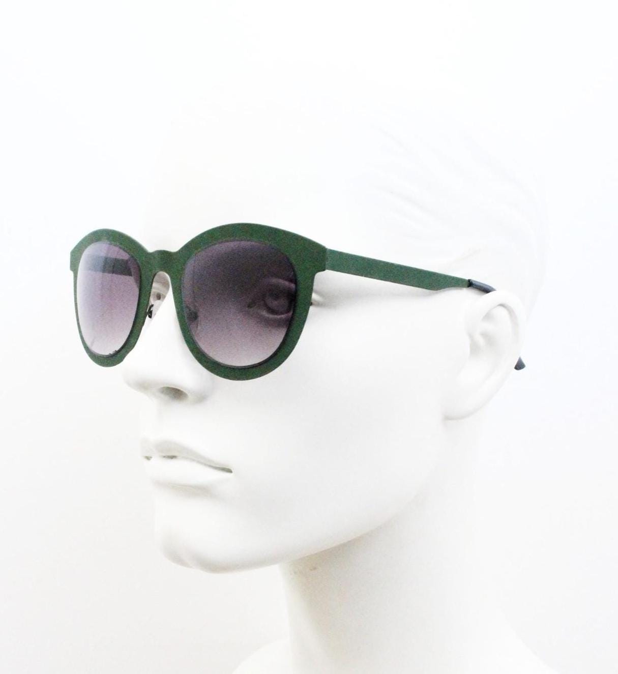 Round vintage cat eye sunglasses. Green flat metal frame in a slightly rubber finish that encases the lenses. Womens 2000s modified cateye