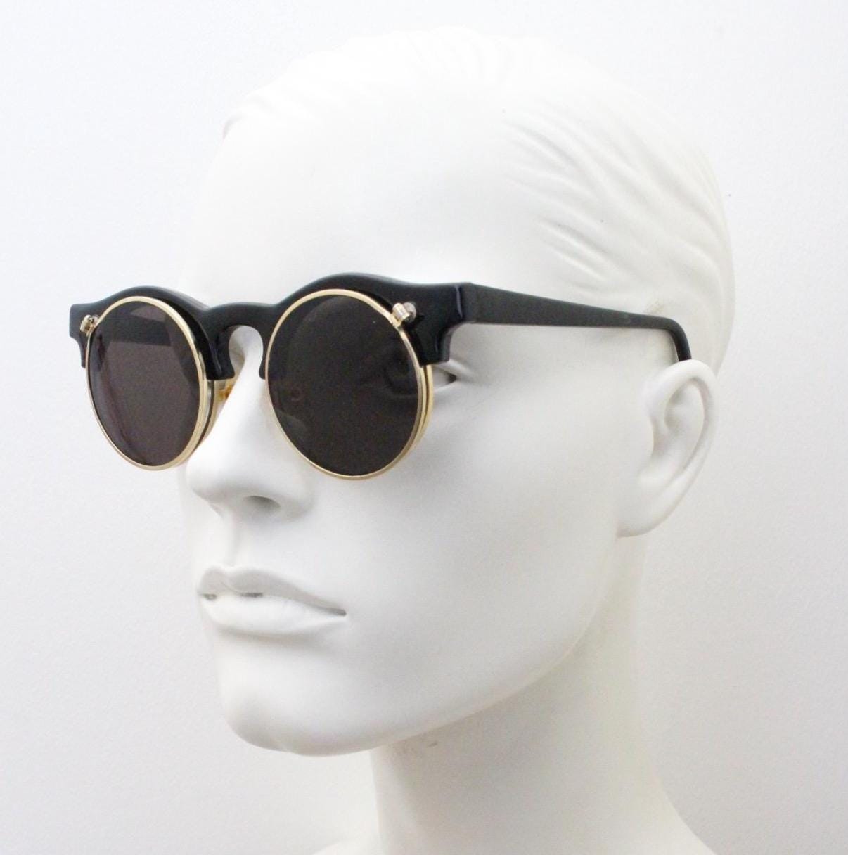 Vintage 80s round flipper sunglasses. Black gloss frame with clear lenses and incredible side flip up shades . BNWT unused NOS