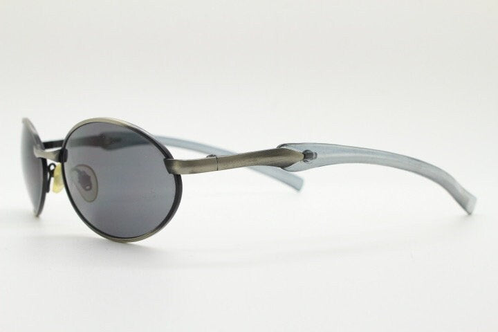 90s vintage small oval  bug eye sunglasses. Brushed bronze finish frame with transparent grey arms. Y2K. 2000s. Unworn NOS