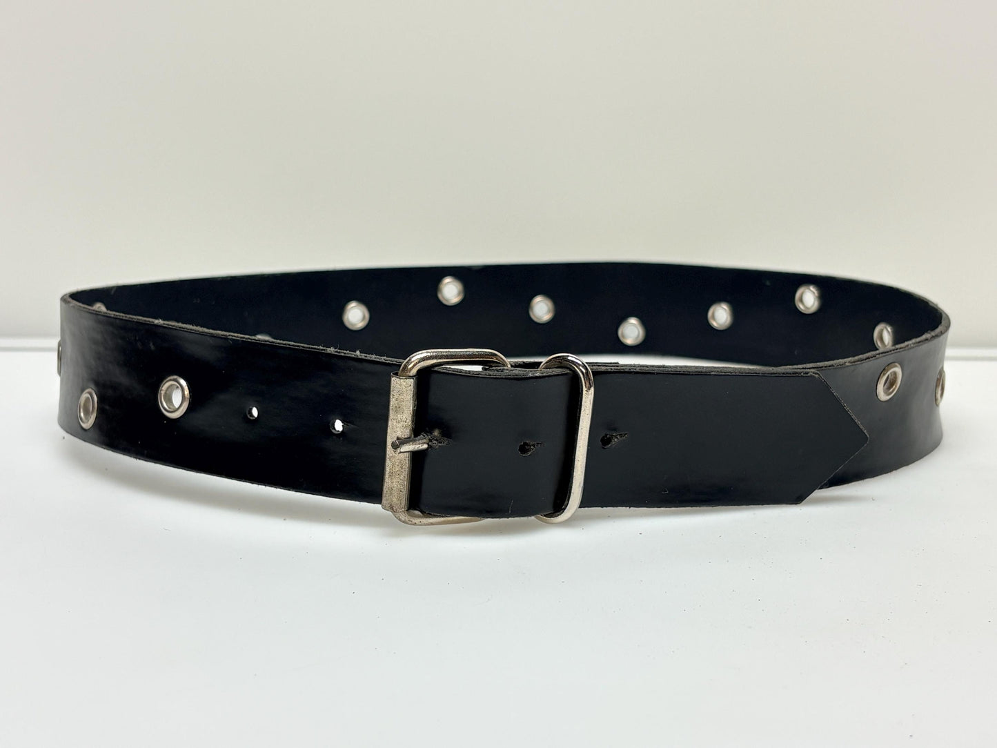 Y2k vintage womens jeans belt with silver buckle and scattered round lace holes. Thick black vinyl. Can be worn with a dress. 2000s NOS
