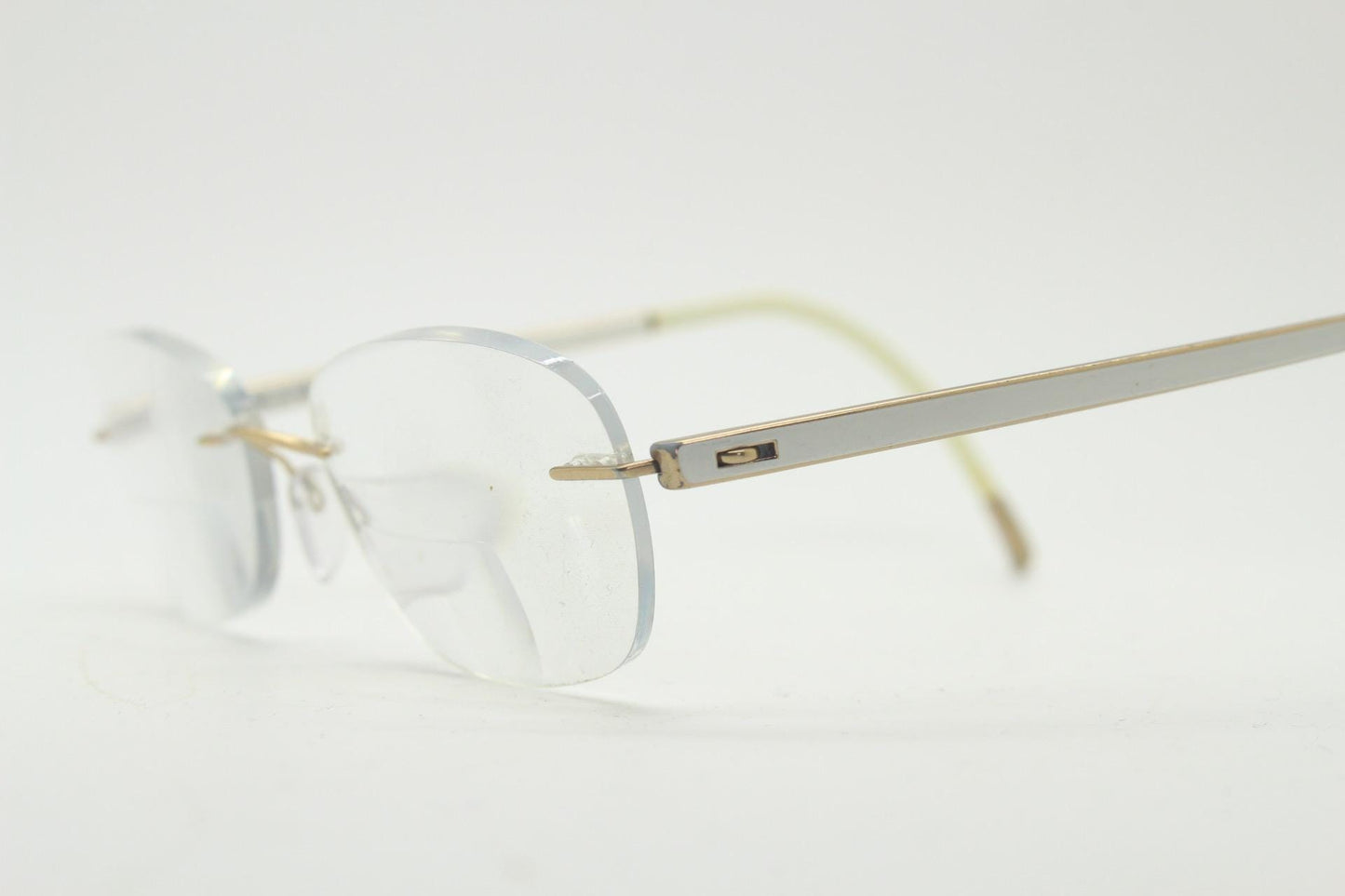 Silhouette rectangular frameless eye glasses made in Austria. Minimal lightweight gold with white enamel frame. 90s vintage. Prescription RX