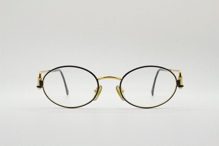 Gianfranco Ferre 90s vintage oval eye glasses made in Italy. Black and gold metal tech design optical frame. Prescription RX. NOS