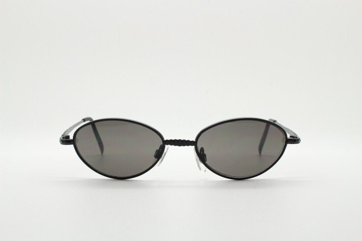 90s vintage oval sunglasses. Minimal plain matt black metal frame with unusual indented arm patterns. Unused NOS