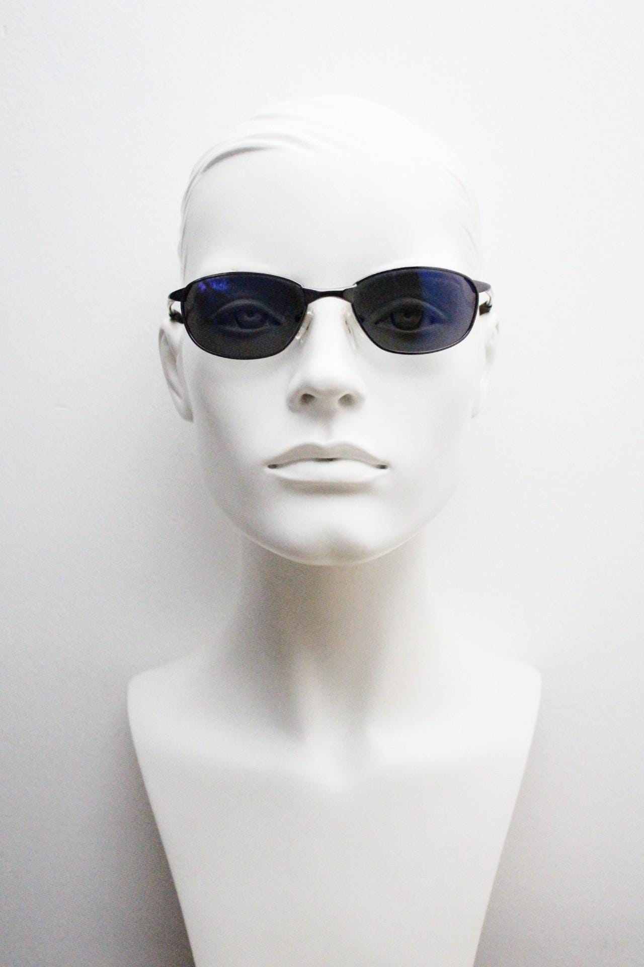 90s vintage curved oval sunglasses. Solid metal low profile frame in grey chrome with slightly mirrored dark lenses. 2000's. Y2K NOS