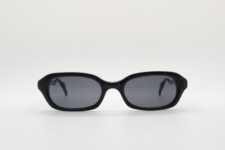 90s vintage rectangular minimal cat eye sunglasses. Small black acetate low profile frame with extraordinary waved arms. Unused NOS