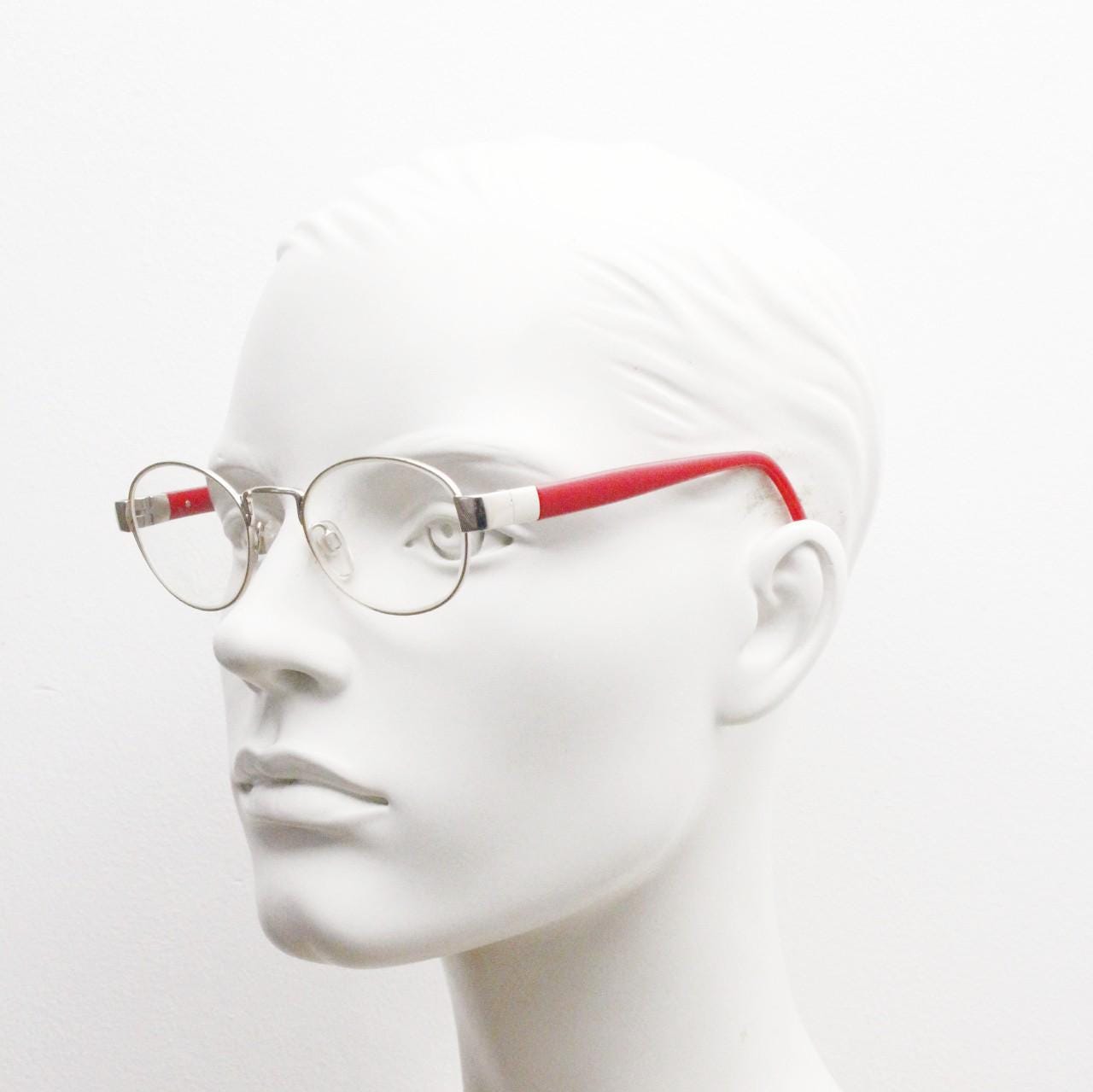 Red or Dead Y2K vintage oval eye glasses. Green or red interchangeable arms on a chrome metal frame. Optical prescription eyeglasses. RX