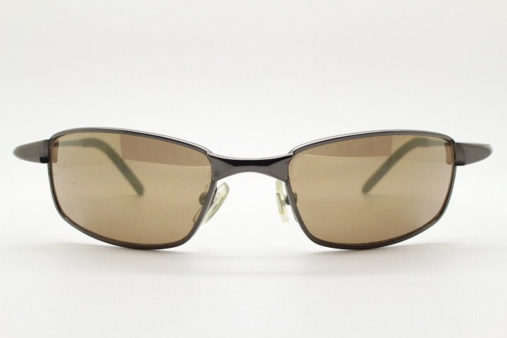 90s vintage curved rectangular sunglasses. Solid metal low profile frame in brown chrome with slightly mirrored lenses. 2000's. Y2K NOS