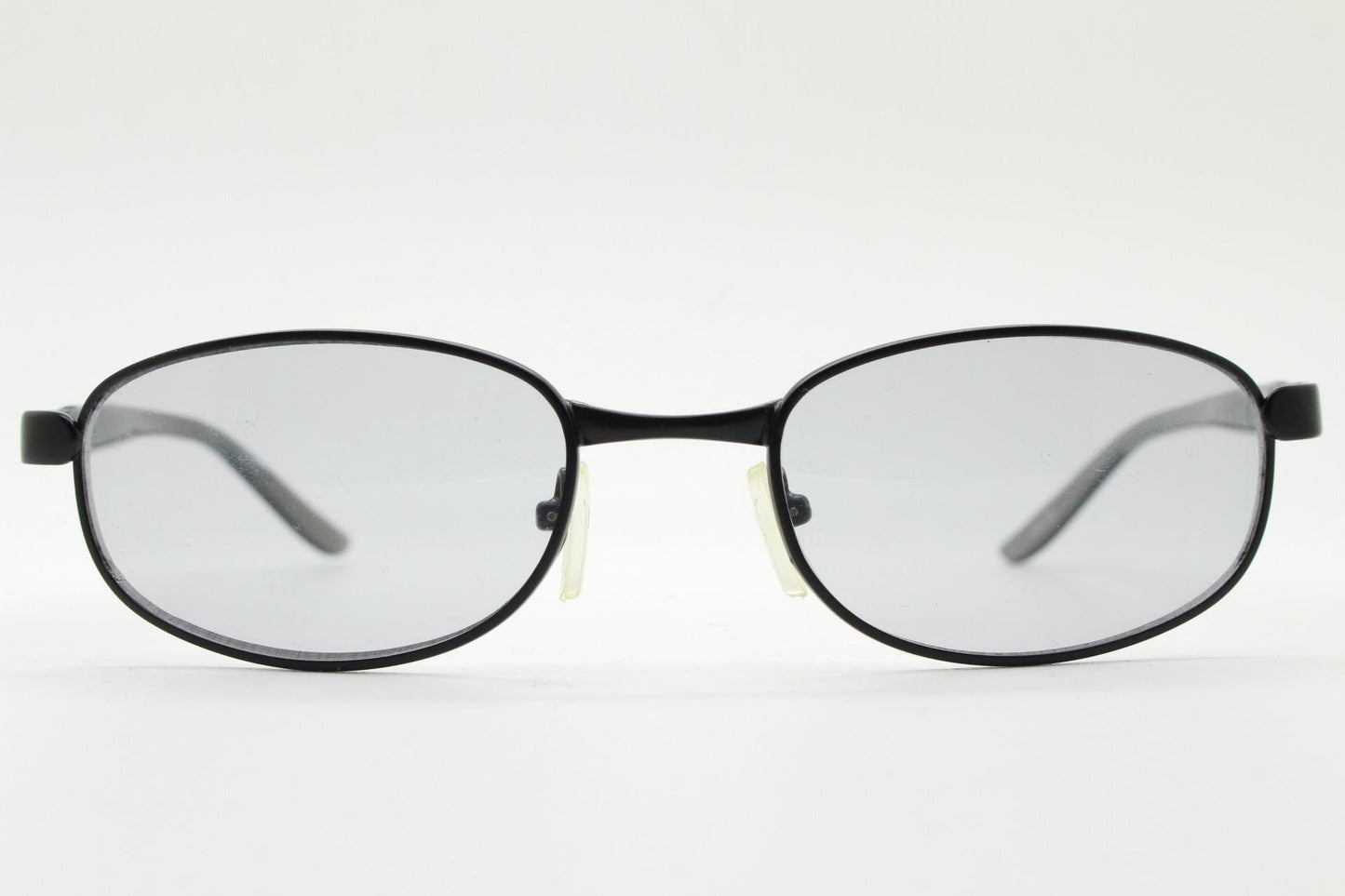 90s vintage oval small bug eye sunglasses. Curved black satin finish metal frame with transparent grey arms and light tone lenses. NOS