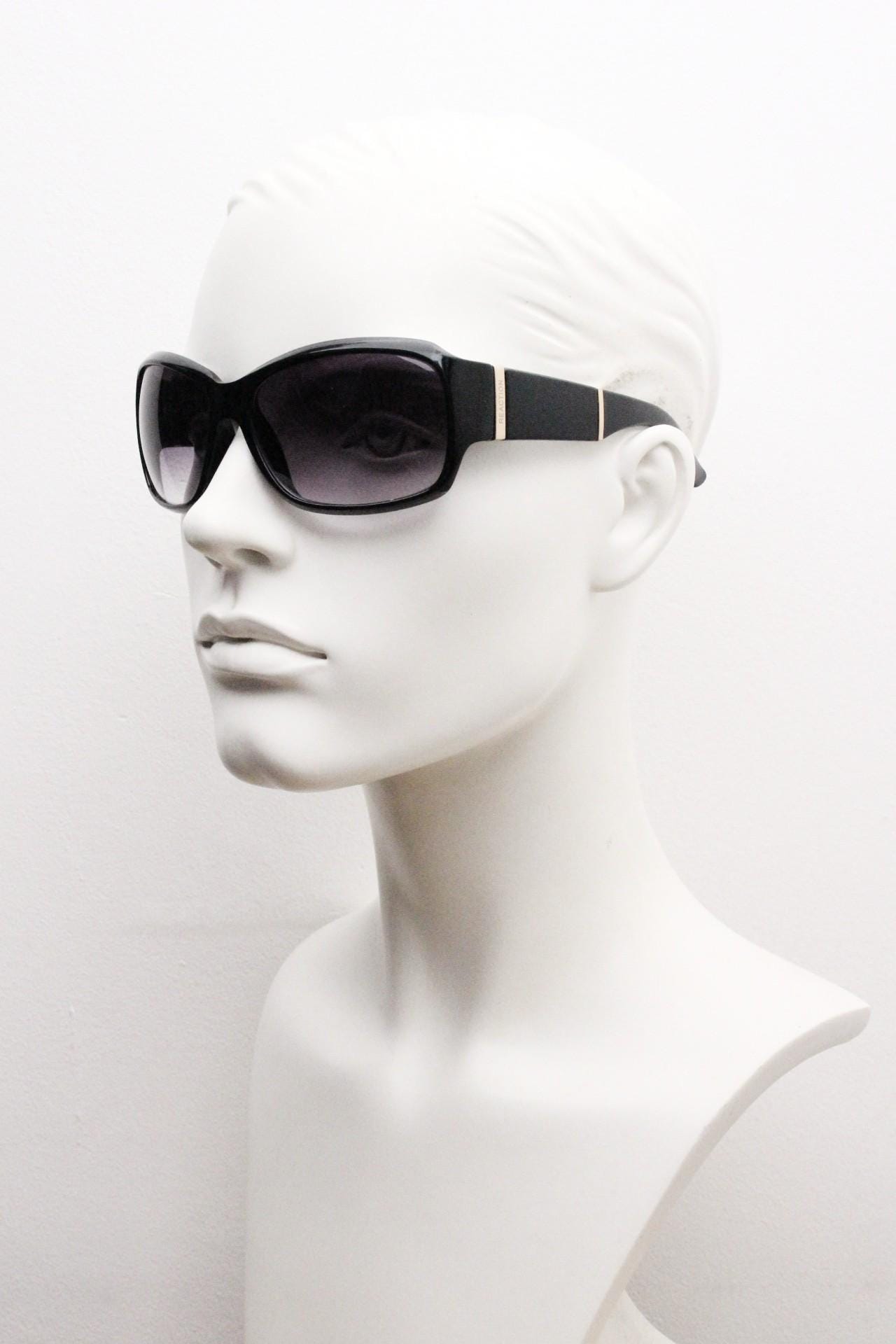 Y2k vintage wrap around sunglasses by Kenneth Cole Reaction. Curved black shield frame with gold trim. 60s bug eye design. 2000's NOS