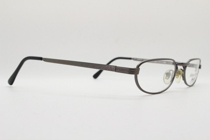 Alberta Ferretti 90s vintage oval eye glasses made in Italy. Small grey metal optical frame with ornate arm pattern. Prescription RX. NOS