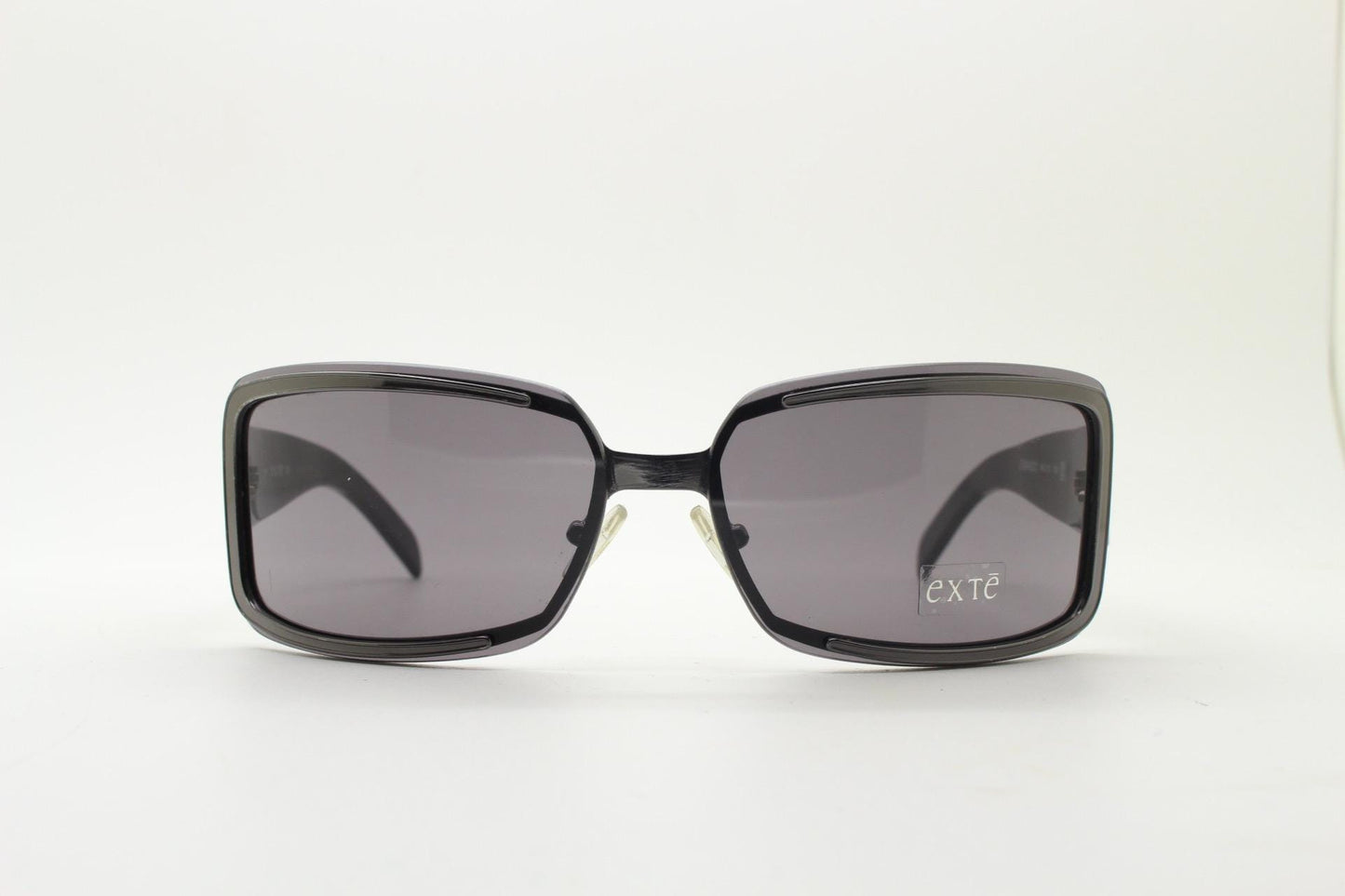 Exte wrap around 90s vintage sunglasses made in Italy. Grey metal front with black acetate arms and curved lenses in neat proportions. BNWT