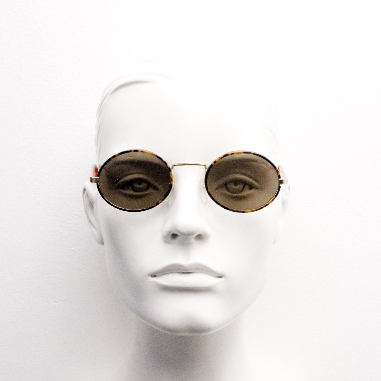 90s vintage oval sunglasses. Handsome honey tortoise and blazing amber arm combo on a slender metal frame. NOS