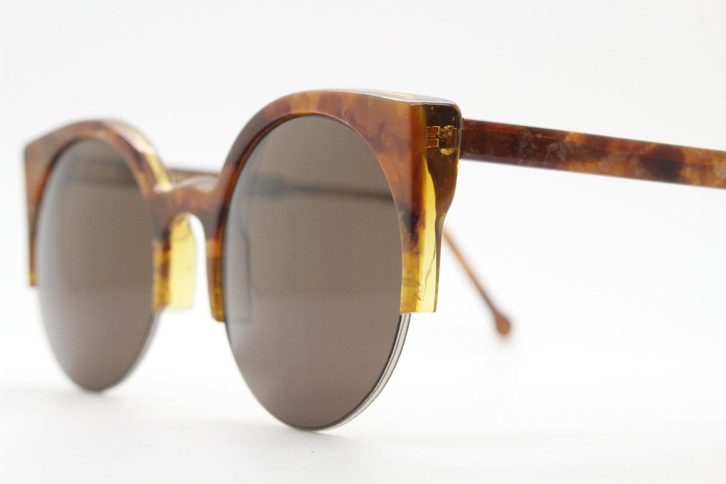 Retrosuperfuture vintage angular cat eye sunglasses made in Italy. Marbled brown gloss acetate flat top half frame with round lenses