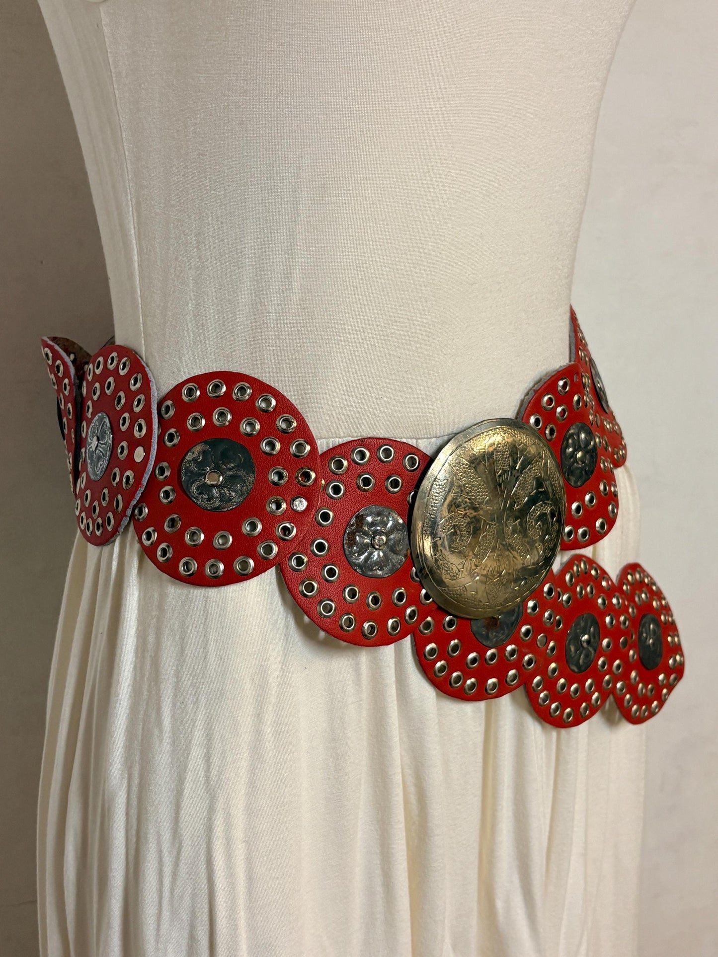 80s vintage womens huge red leather circles belt. Versatile statement piece with holed studs, metal discs and big 'shield' buckle. NOS