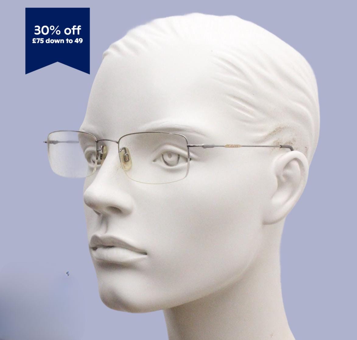 A mannequin head wearing a pair of rimmed glasses against a light blue background.