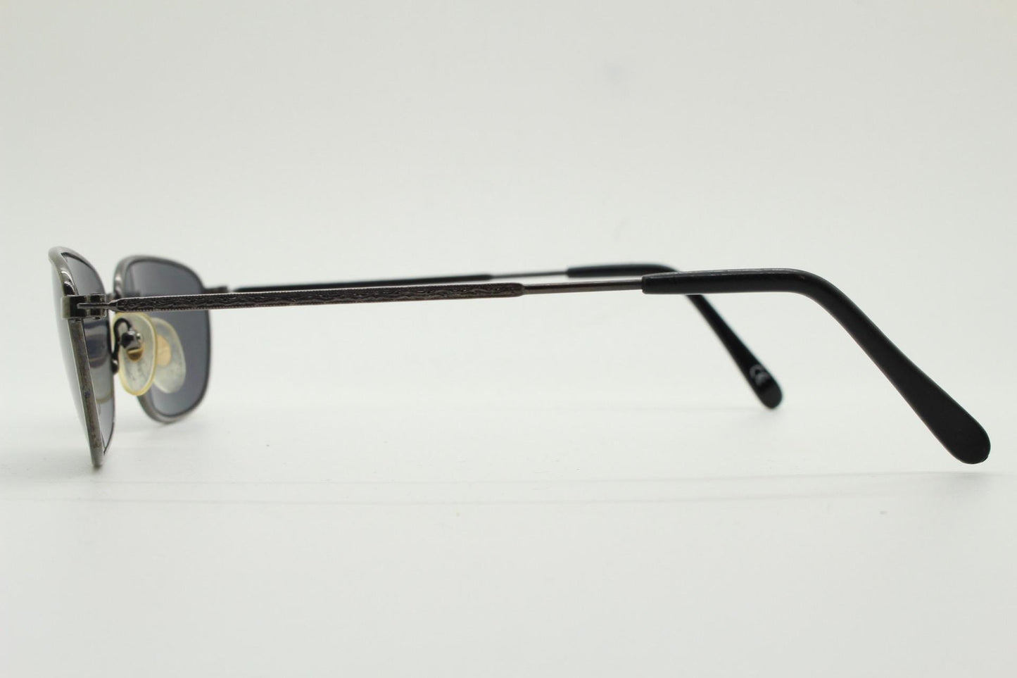 90s vintage angular pointed sunglasses. Minimal grey chrome metal frame with embossed patterned arms. Subtle cat eye. NOS