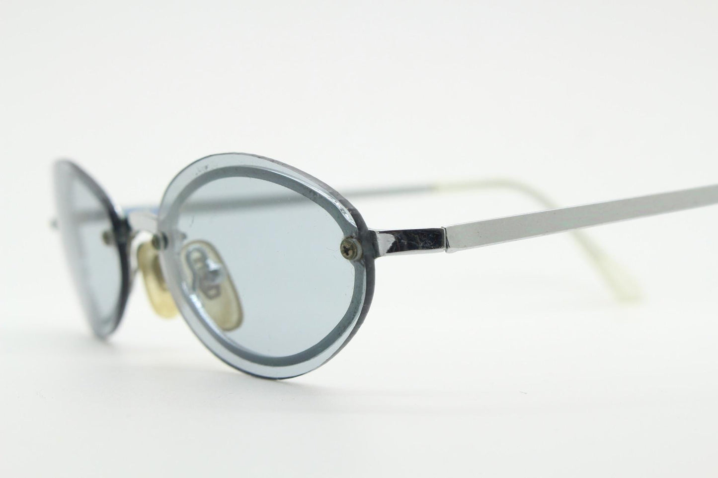 90s vintage small oval sunglasses. Minimal silver chrome metal frame with overlapping light tone grey lenses. Micro. Steampunk