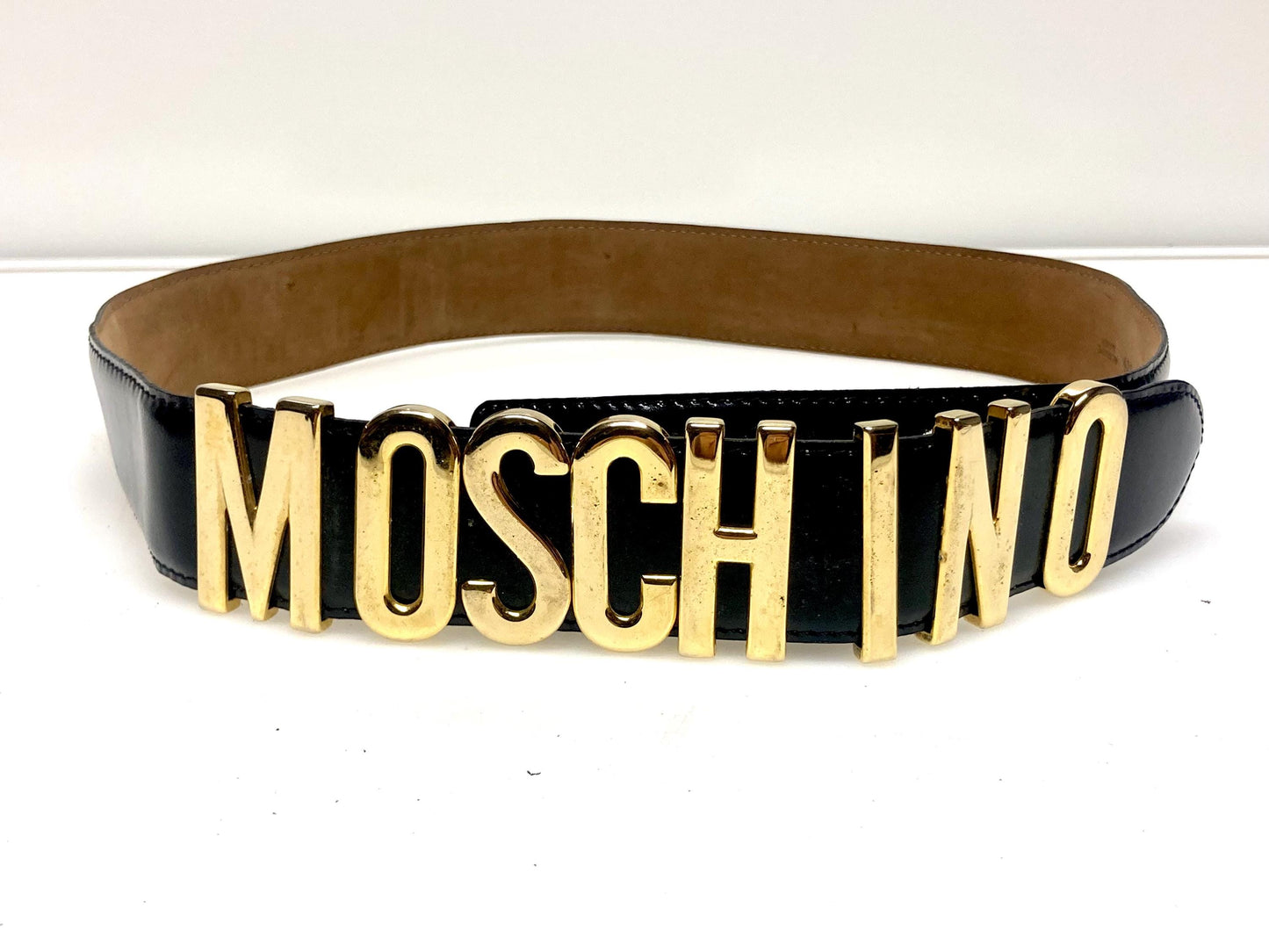 Moschino 90s vintage womens dress belt in black genuine leather. Iconic individual golden moving letters logo. Made in Italy. 80s. NOS