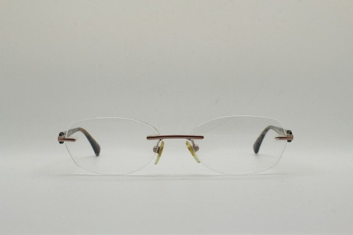 Vogue vintage frameless oval eye glasses. Transparent acetate arms with purple and green tones. Minimal Prescription RX Optical frame