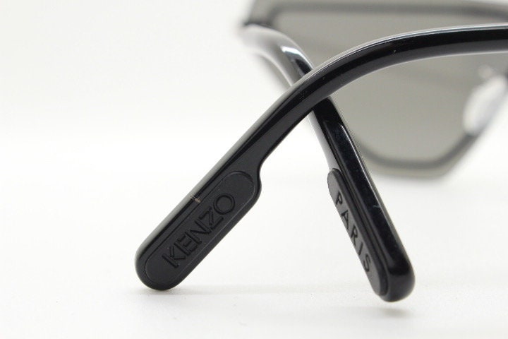 Kenzo flat screen triangular futuristic cat eye. Slight mirror glaze mono lens on black matt metal wire frame. NOS Cateye